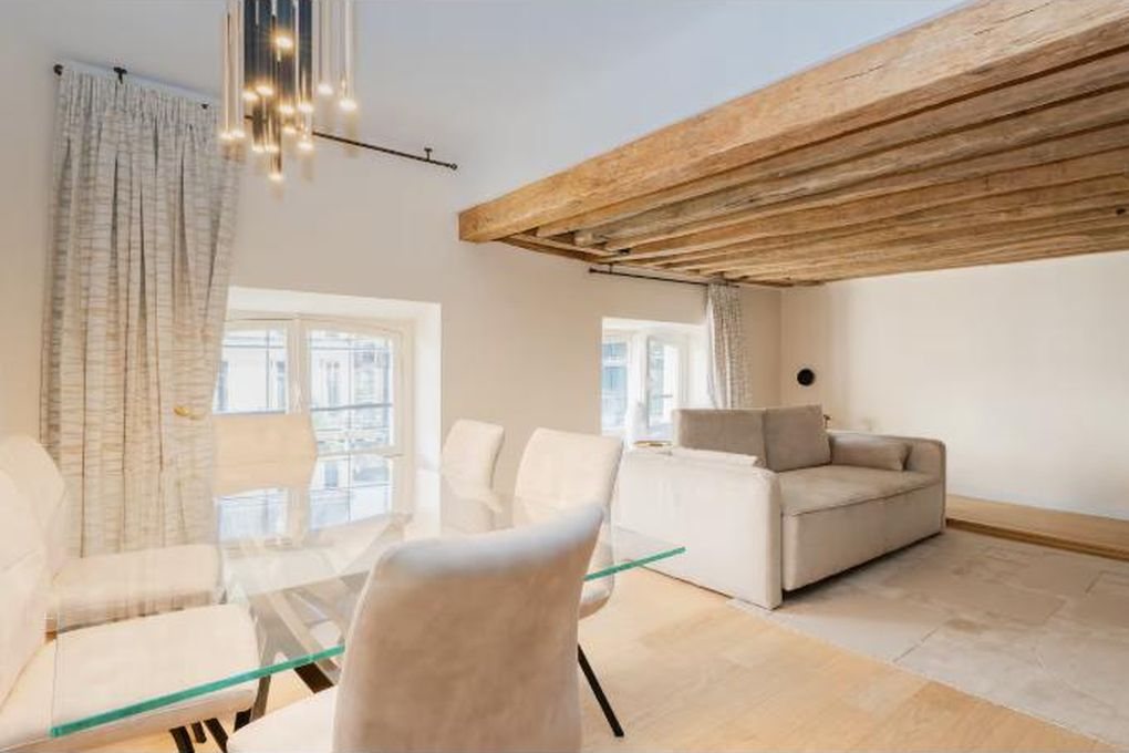 Le séjour du 15 rue Danielle Casanova, poutres apparentes et table de verre